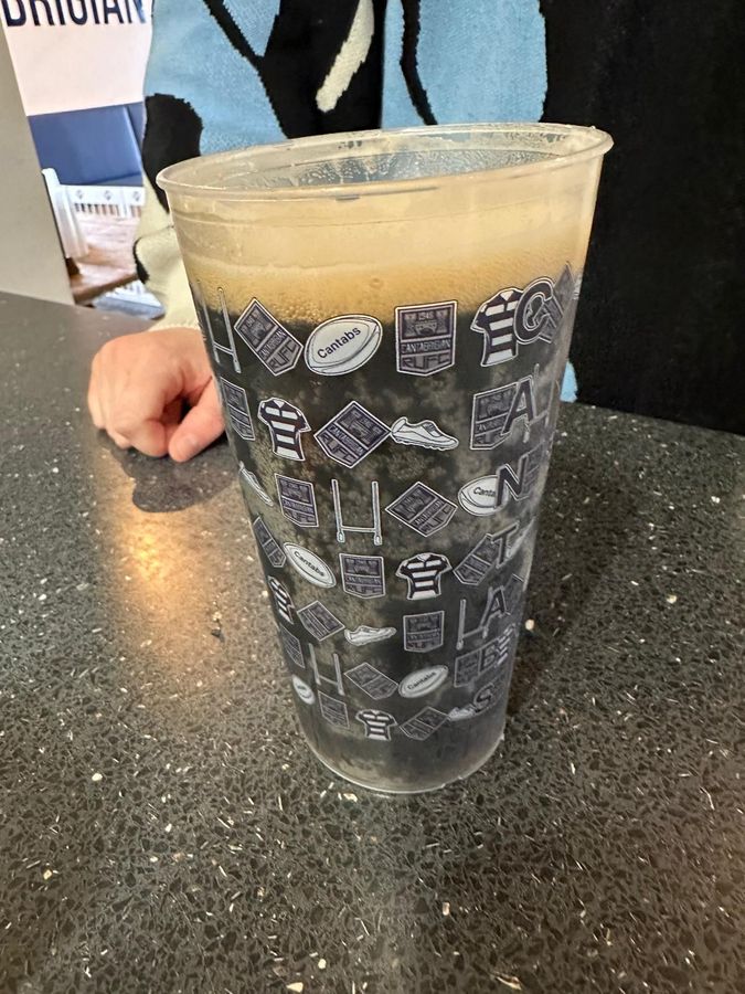 A Cantabs-branded festival cup filled with dark stout on the clubhouse bar