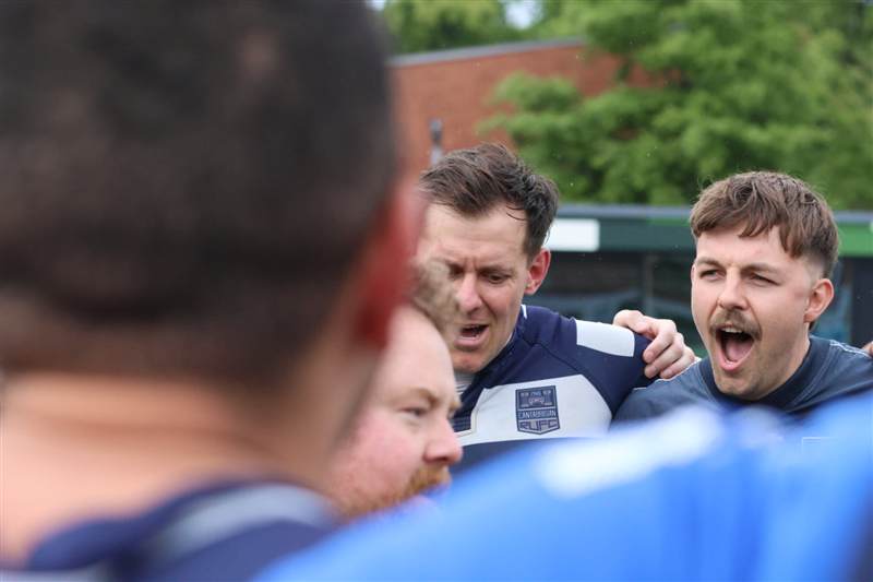 Club photo: players roar together inside a tight huddle