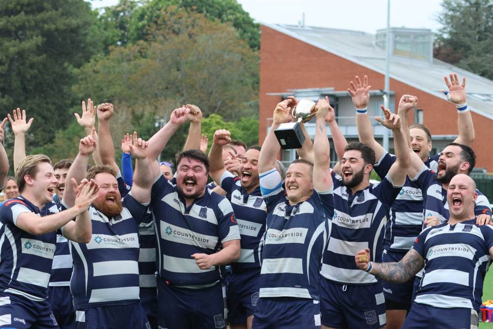 Club photo: the squad hoists the cup with every arm raised